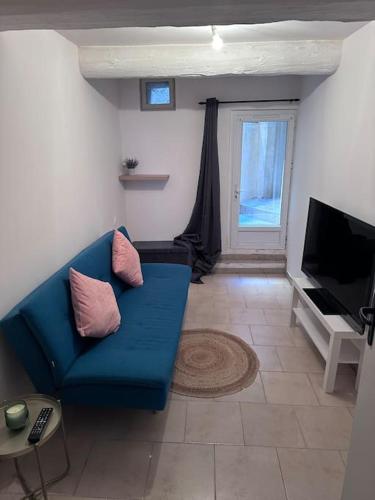 un salon avec un canapé bleu et une télévision dans l'établissement Détente en centre ville, à Sorgues