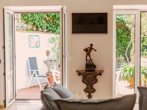 a living room with a couch and a television at Casa Silvana, Capri - Relaxando en el verde in Capri
