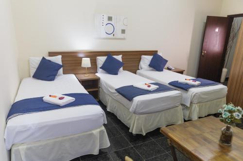 a hotel room with two beds and a table at VILLAGE GOLDEN HOTEL in Jales