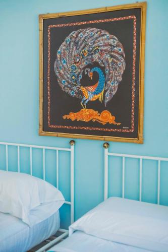 a painting of a peacock on a wall above a bed at Casa Silvana, Capri - Relaxando en el verde in Capri