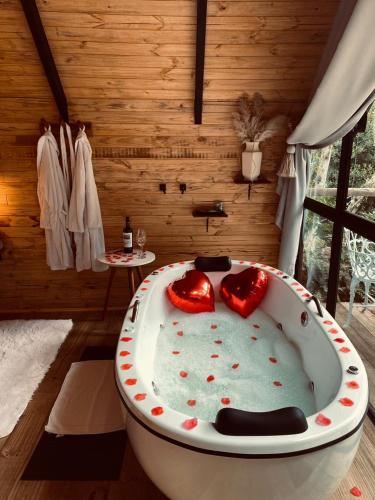a bath tub with two hearts in a room at chalé Platanus in Campos do Jordão