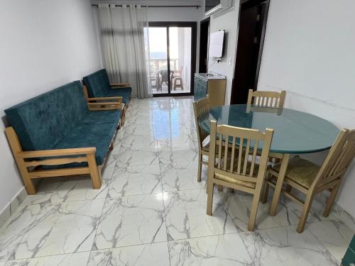 - un salon avec une table, des chaises et un canapé dans l'établissement Porto Said Rental - بورتو سعيد, à `Ezbet Shalabi el-Rûdi