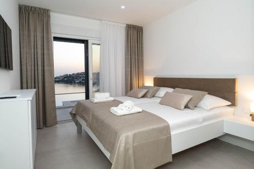 a bedroom with a large bed and a large window at Villa Laganini in Rogoznica