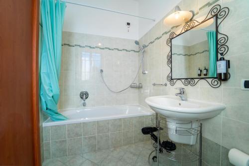 ein Badezimmer mit einem Waschbecken und einer Badewanne in der Unterkunft SuiteRho [FreeParking] in Rho
