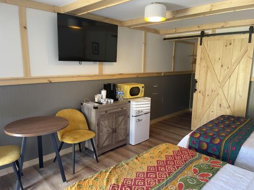 Zimmer mit einem Bett, einem Tisch und einem TV in der Unterkunft Sweet Forest Breeze, A Cook Forest Inn in Marienville