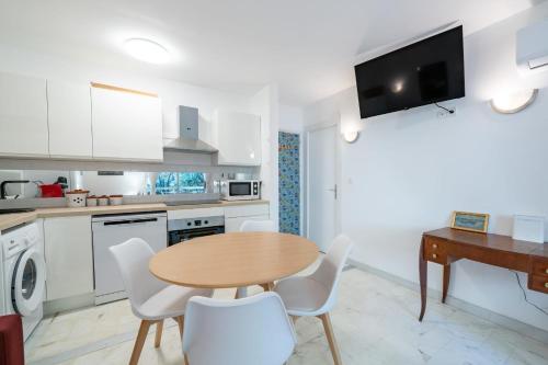 cocina con mesa de madera y sillas blancas en Nice one bedroom close to the center of Cannes, en Cannes