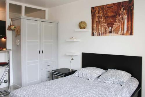 een slaapkamer met een bed en een witte kast bij Nice studio close to Paris in Montrouge