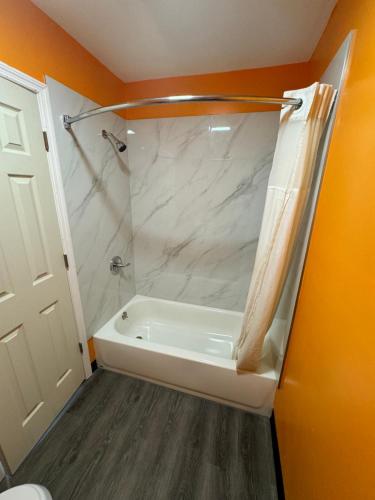 a bathroom with a shower and a white tub at Budget Inn Decatur Priceville in Decatur