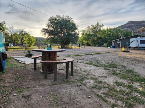 una mesa de picnic y bancos en un aparcamiento en #6 Wild West, en Drumheller