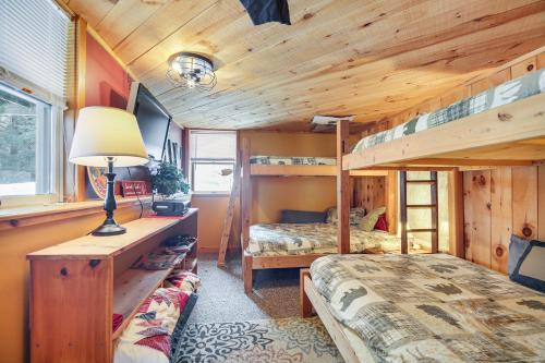 a bedroom with two bunk beds and a lamp at Waitsfield Home with Hot Tub - Close to Sugarbush! in Waitsfield