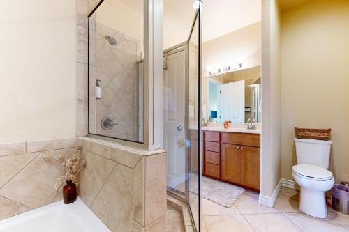 a bathroom with a shower and a toilet and a sink at Treetop on LBJ in Kingsland