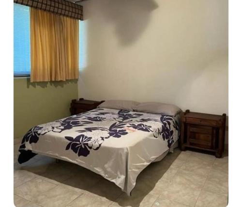 um quarto com uma cama com um edredão preto e branco em Amplio Apto al este de Caracas em Caracas