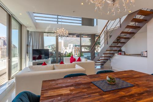 uma sala de estar com um sofá e uma mesa em Mirage by McStay em Cidade do Cabo