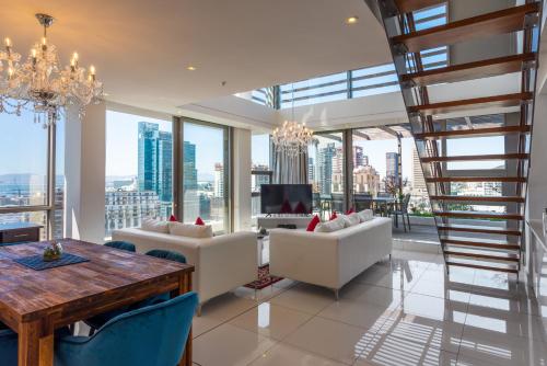 uma sala de estar com um lustre e janelas grandes em Mirage by McStay em Cidade do Cabo