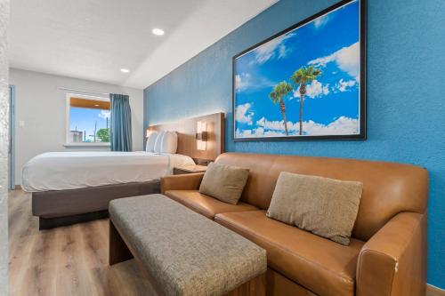 een hotelkamer met een bank en een bed bij Econo Lodge Inn & Suites Sealy in Sealy