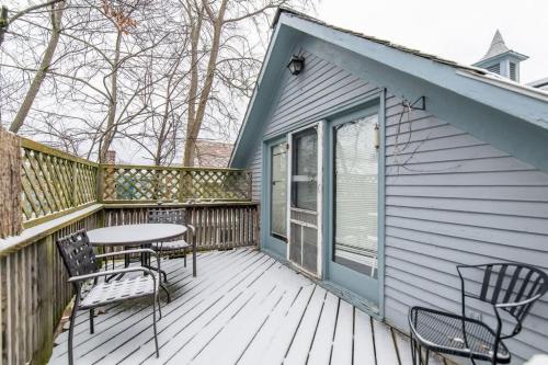 a patio with chairs and a table on a deck at Bright and Cozy Treehouse Apartment in Burlington