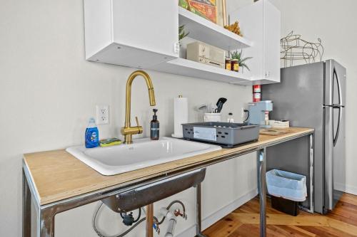 a kitchen with a sink and a refrigerator at The Brick House-Walk DT or U of A- 3 Suites in Fayetteville