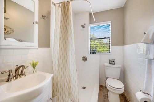 a white bathroom with a sink and a toilet at The Clementine - Monthly Rental - Walk Everywhere in Fayetteville