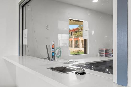 een badkamerbar met een spiegel en een wastafel bij Econo Lodge Inn & Suites Sealy in Sealy