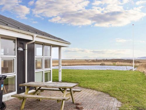 a picnic table outside of a house with a lake at 4 person holiday home in Thisted-By Traum in Thisted