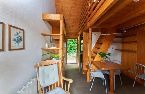 Cette chambre dispose d'une table, de chaises et de plafonds en bois. dans l'établissement Alsace Village, à Obersteinbach