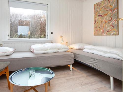 RøndeにあるHoliday home Røndeの窓とテーブル付きの部屋のベッド2台