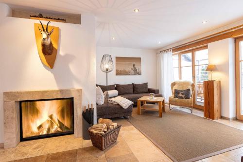 sala de estar con sofá y chimenea en Ferienlandhaus Alpinum, en Lenggries