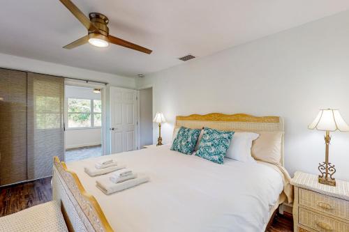 1 dormitorio con 1 cama blanca y ventilador de techo en The Wicker Wonder en Lake Placid