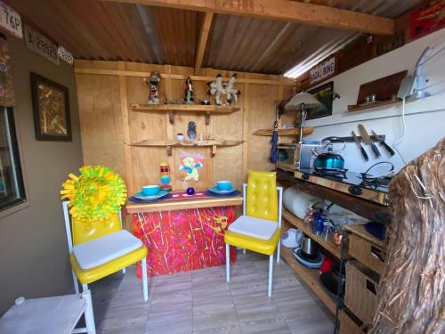 Sedona Camp Tiny House في سيدونا: مطبخ مع كرسيين اصفر وطاولة