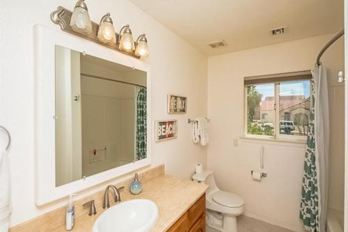 a bathroom with a sink and a toilet and a mirror at Sunriver Rendezvous in Bullhead City