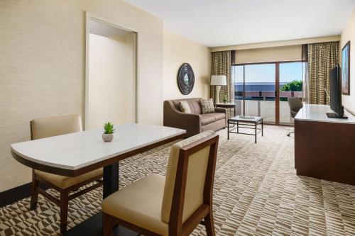 a living room with a table and chairs and a living room at Hilton Phoenix Airport in Phoenix