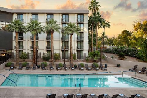 una imagen de un hotel con piscina y palmeras en Embassy Suites by Hilton Phoenix Biltmore en Phoenix