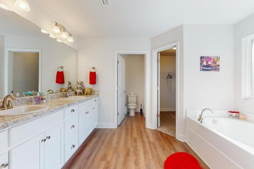 a bathroom with two sinks and a tub and a toilet at Pensacola Heights in Pensacola