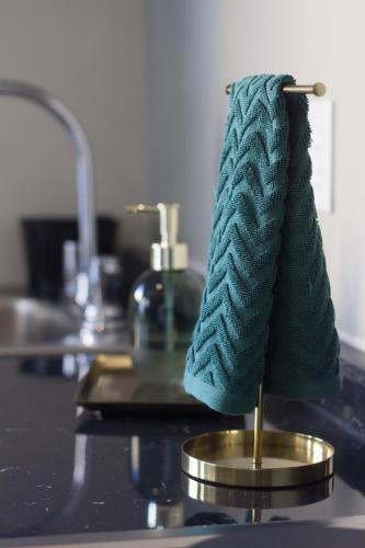 a green towel sitting on a counter next to a sink at Casa Alexia in Guadalajara