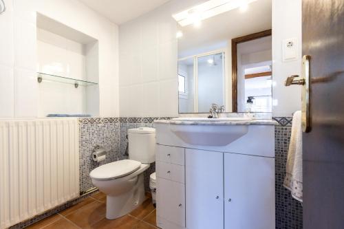 La salle de bains blanche est pourvue de toilettes et d'un lavabo. dans l'établissement Mas Xanxo, à Riudoms