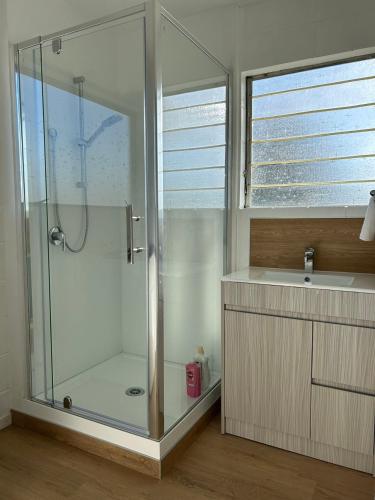 La salle de bains est pourvue d'une douche et d'un lavabo. dans l'établissement Avon Apartments, à Hamilton