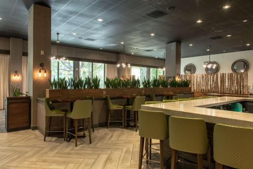 a restaurant with a bar and a swimming pool at Hotel Zessa Orange County Airport, a DoubleTree by Hilton in Santa Ana