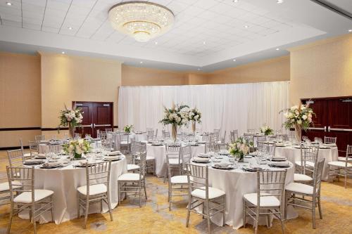 a banquet hall with tables and chairs with flowers at Hotel Zessa Orange County Airport, a DoubleTree by Hilton in Santa Ana