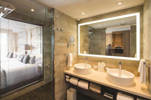 a bathroom with two sinks and a large mirror at Hilton at Resorts World Bimini in Alice Town