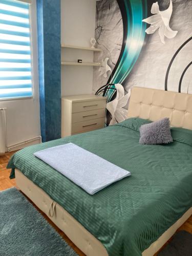 een slaapkamer met een groen bed en een spiegel aan de muur bij Apartman Aleksandar in Nova Varoš