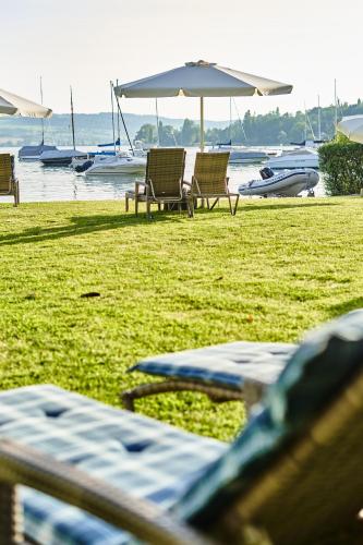 a group of chairs and umbrellas on a beach at Residenz Seeterrasse Restaurant & Hotel in Wangen