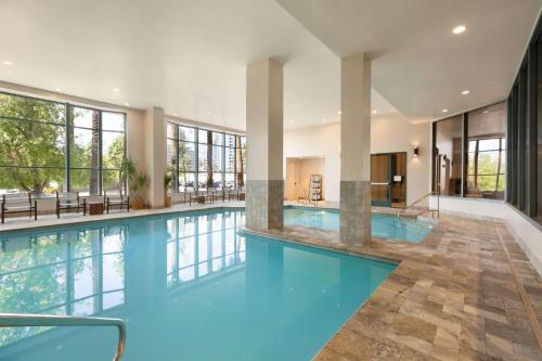 a pool with blue water in a building with windows at Embassy Suites by Hilton Phoenix Downtown North in Phoenix