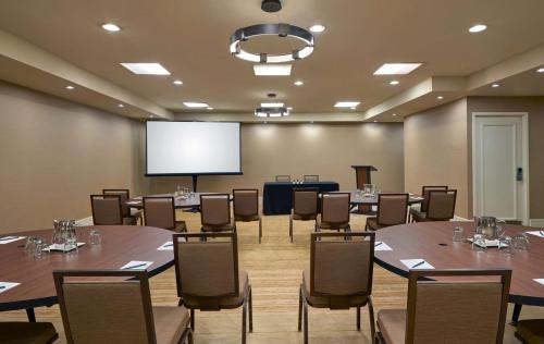 a conference room with tables and chairs and a projection screen at Hilton Denver City Center in Denver