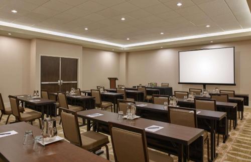 a conference room with tables and chairs and a screen at Hilton Denver City Center in Denver