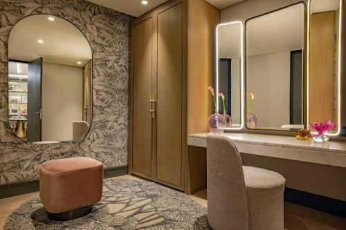 a dressing room with two chairs and a mirror at Waldorf Astoria Cairo Heliopolis in Cairo