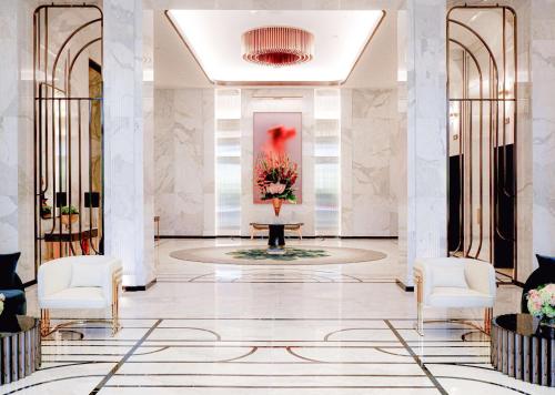 a lobby with white chairs and a vase of flowers at Waldorf Astoria Las Vegas in Las Vegas