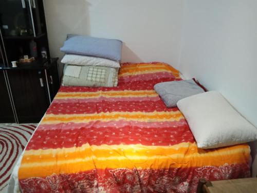 uma cama com um cobertor colorido e almofadas em Casa al mare em Santa Maria Del Focallo