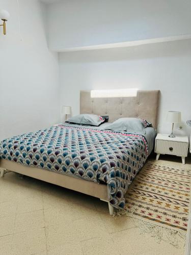 a bedroom with a large bed and a rug at La Perle à Marsa Résidence in Tunis