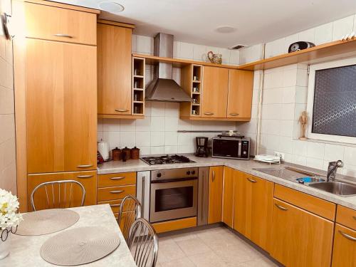 Una cocina con gabinetes de madera y un horno de estufa. en Top Home Residence Unirii Center, en Bucarest