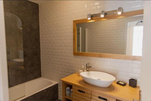 une salle de bain avec un lavabo, un miroir et une baignoire dans l'établissement T2 avec terrasse. Résidence piscine/parking, à Saint-Tropez